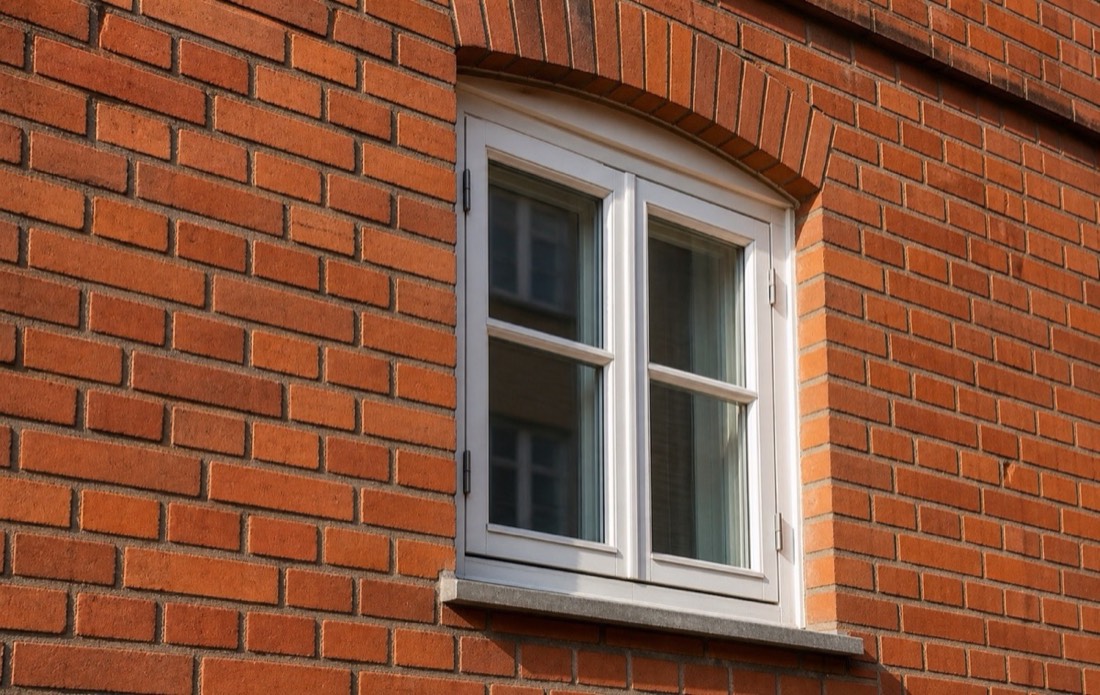 Tegelfasad med fönster och renoverade fogar